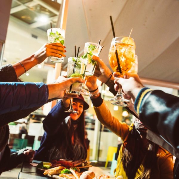 group-of-friends-wearing-protective-face-masks-drinking-cocktails-at-night-bar.jpg