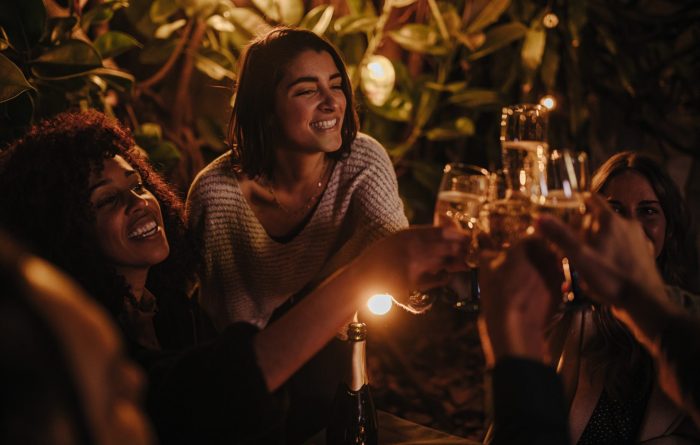 happy-young-adult-friends-celebrating-with-drinks-at-bar-together-in-the-evening.jpg